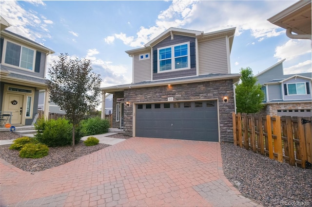 213 S Old Hammer Ct, Aurora, CO 80018 - craftsman-style home featuring an attached garage, stone siding, and decorative driveway