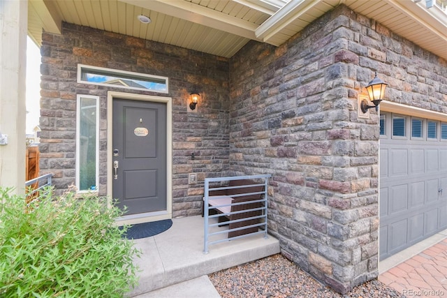 213 S Old Hammer Ct, Aurora, CO 80018 - property entrance with a garage and stone siding