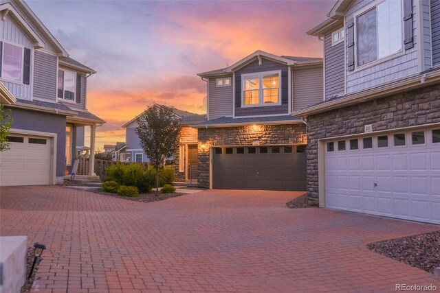 213 S Old Hammer Ct, Aurora, CO 80018 - garage at dusk featuring decorative driveway