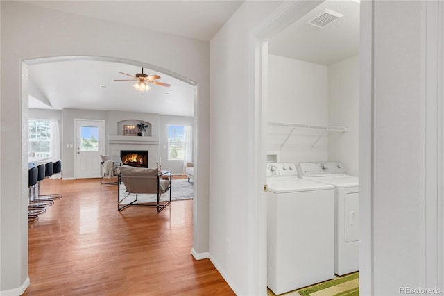 23612 E Mississippi Cir, Aurora, CO 80018 - washroom with washer and clothes dryer, light wood-style flooring, a lit fireplace, and a ceiling fan