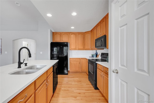 23612 E Mississippi Cir, Aurora, CO 80018 - kitchen with black appliances, light wood-style floors, recessed lighting, light countertops, and arched walkways