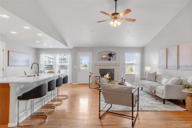23612 E Mississippi Cir, Aurora, CO 80018 - living room with vaulted ceiling, a tile fireplace, healthy amount of natural light, light wood-style floors, and recessed lighting