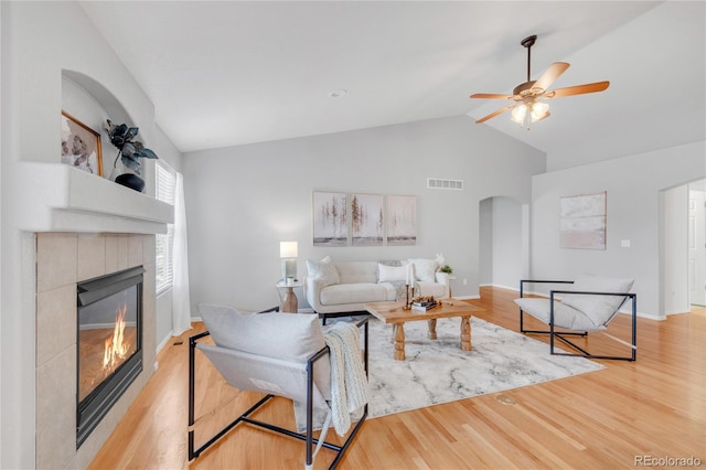 23612 E Mississippi Cir, Aurora, CO 80018 - living room with arched walkways, a ceiling fan, high vaulted ceiling, a fireplace, and light wood-style flooring