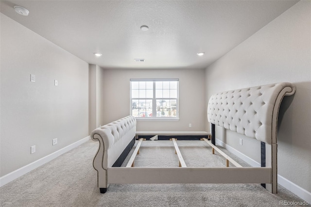 carpeted bedroom featuring a textured ceiling