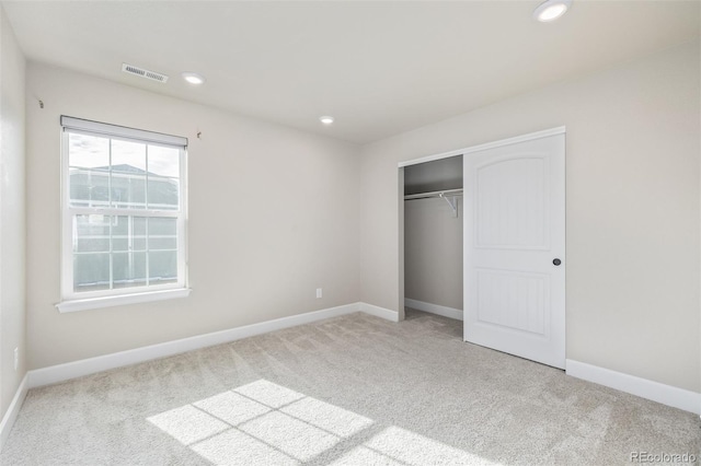 unfurnished bedroom with a closet and light carpet