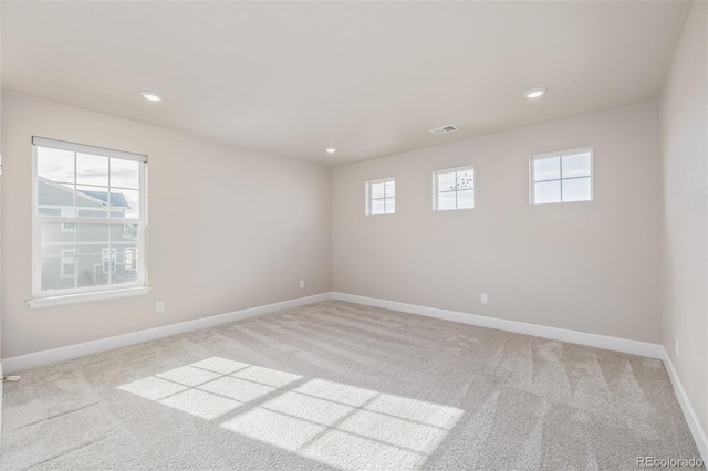 unfurnished room featuring light carpet and a healthy amount of sunlight