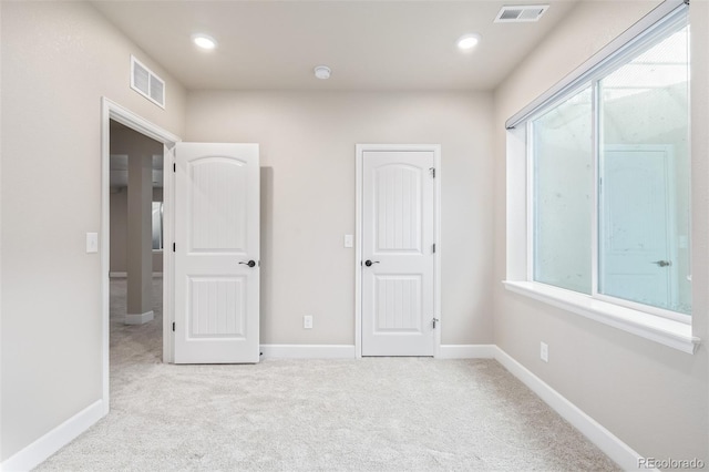 unfurnished bedroom featuring light carpet