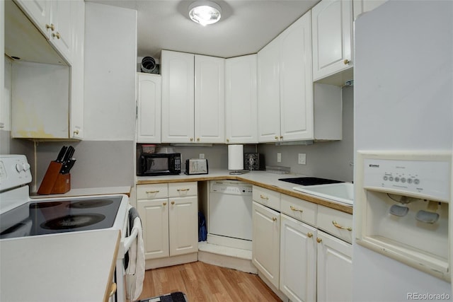 kitchen with white cabinets, light wood-type flooring, and white appliances