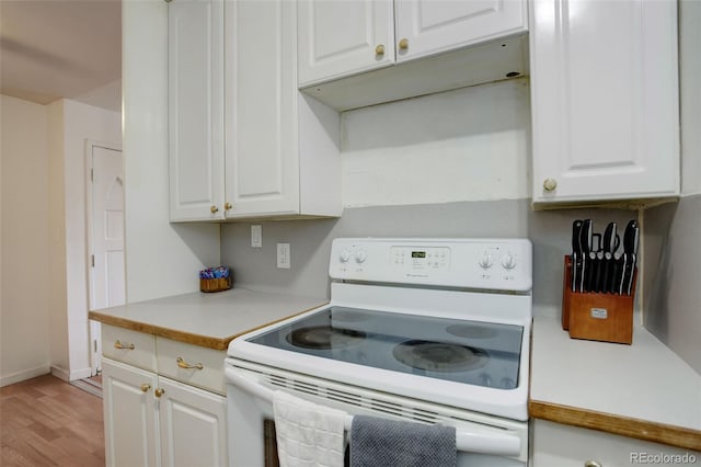 kitchen with white cabinets, white electric range, and light wood-type flooring