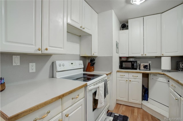 kitchen with light hardwood / wood-style floors, white cabinets, and white appliances