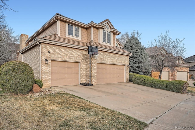 view of front of property with concrete driveway, brick siding, a garage, and a chimney