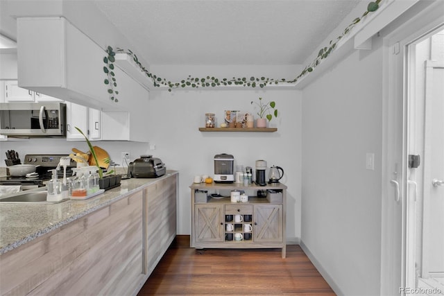 kitchen featuring range, a textured ceiling, dark hardwood / wood-style flooring, and white cabinets