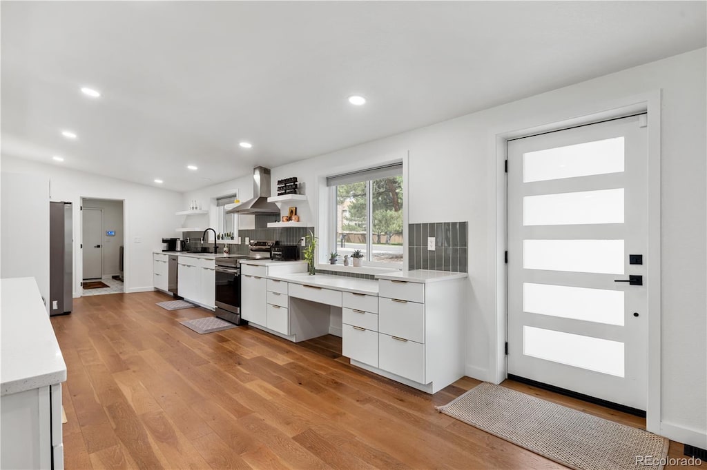 2175 S Joliet St, Aurora, CO 80014 - kitchen featuring appliances with stainless steel finishes, wall chimney exhaust hood, modern cabinets, white cabinetry, and open shelves
