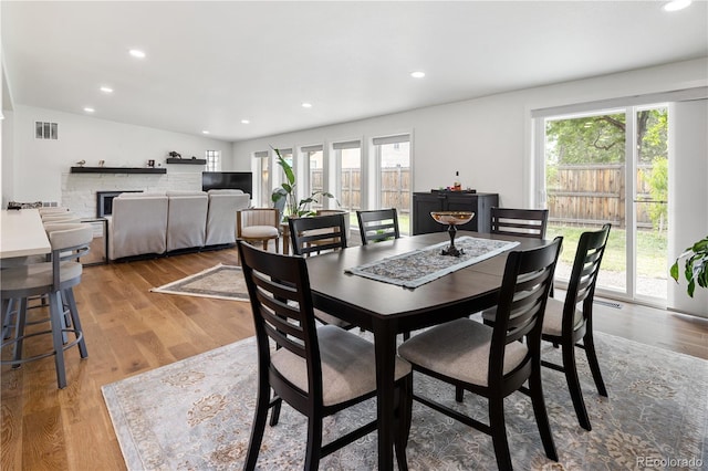 2175 S Joliet St, Aurora, CO 80014 - dining space featuring healthy amount of natural light, light wood-style floors, recessed lighting, vaulted ceiling, and a fireplace