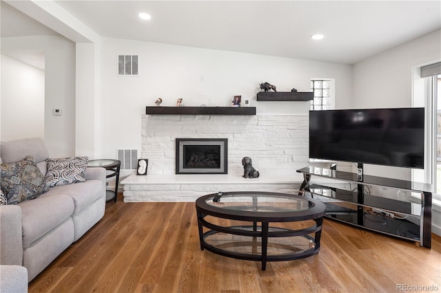 2175 S Joliet St, Aurora, CO 80014 - living room featuring healthy amount of natural light, wood finished floors, a stone fireplace, and recessed lighting