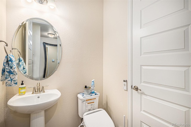 half bath featuring a sink and toilet