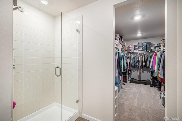 full bath featuring recessed lighting, baseboards, a spacious closet, and a shower stall