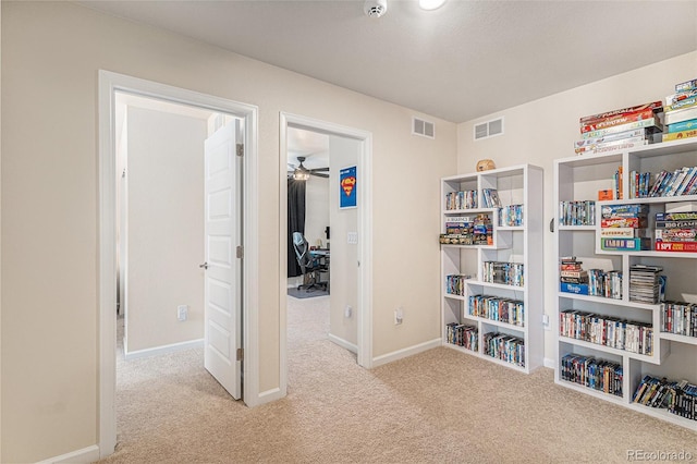 interior space with carpet floors, ceiling fan, and visible vents