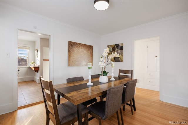 dining area with crown molding and light hardwood / wood-style floors