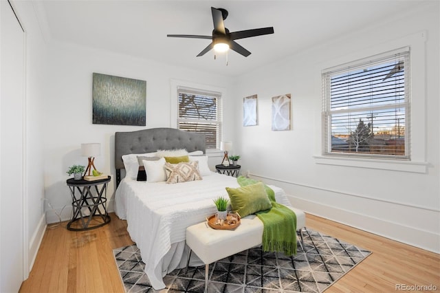 bedroom featuring wood-type flooring, ornamental molding, and ceiling fan