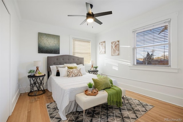 bedroom with crown molding, ceiling fan, and hardwood / wood-style floors