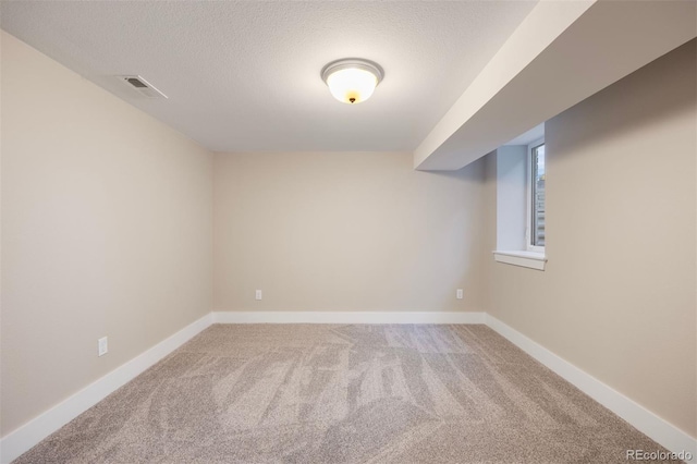 spare room with carpet flooring and a textured ceiling