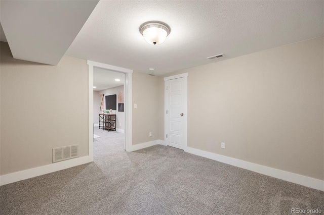 unfurnished room with a textured ceiling and carpet flooring