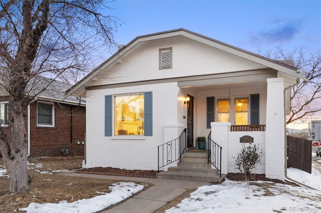 view of front of home with brick siding and a porch