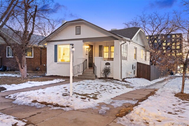 bungalow-style house with brick siding and fence