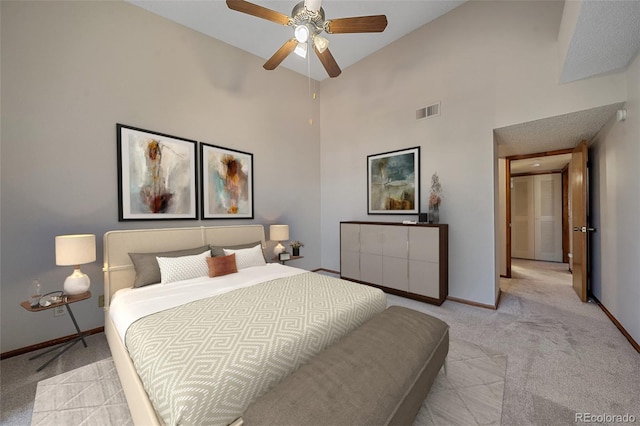 bedroom featuring a high ceiling, ceiling fan, and light colored carpet