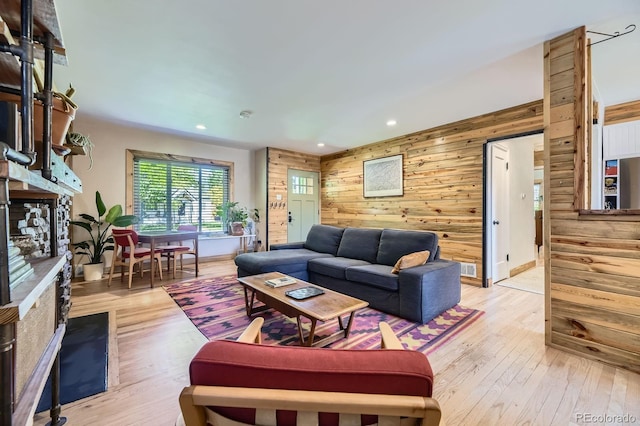 2844 Bellaire St, Denver, CO 80207 - living room with wood walls, a fireplace, light wood-style floors, and recessed lighting
