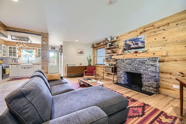 2844 Bellaire St, Denver, CO 80207 - living room with light wood-type flooring, wooden walls, recessed lighting, and a fireplace