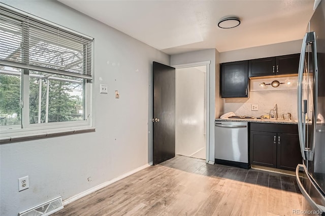 5274 Alkire St, Arvada, CO 80002 - kitchen with stainless steel appliances, light wood finished floors, light stone countertops, and dark cabinets