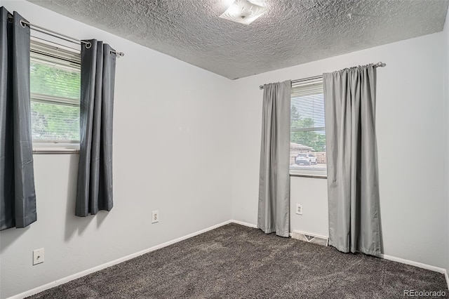 5274 Alkire St, Arvada, CO 80002 - unfurnished room featuring healthy amount of natural light, a textured ceiling, and dark carpet