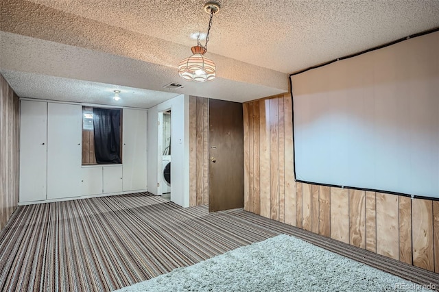 5274 Alkire St, Arvada, CO 80002 - cinema with carpet floors, a textured ceiling, wooden walls, and washer / dryer