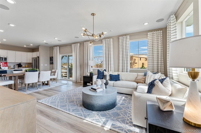23782 E 33rd Pl, Aurora, CO 80019 - living room featuring healthy amount of natural light, light wood finished floors, a chandelier, and recessed lighting