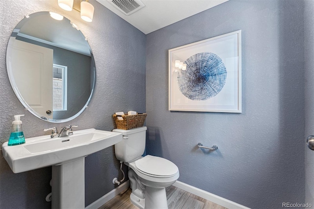 23782 E 33rd Pl, Aurora, CO 80019 - half bath featuring wood finished floors, toilet, baseboards, and a textured wall