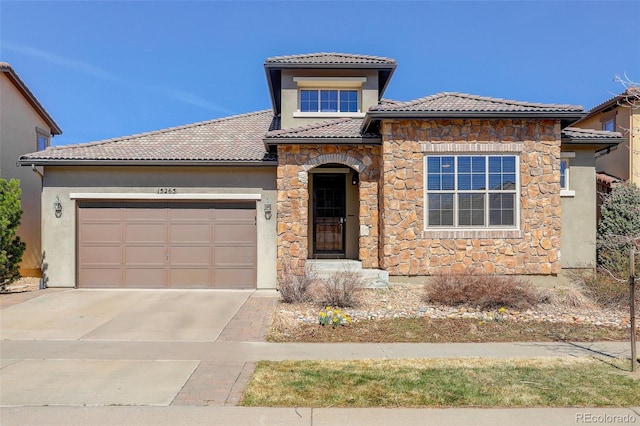 view of front of home featuring an attached garage, concrete driveway, stucco siding, and a tile roof