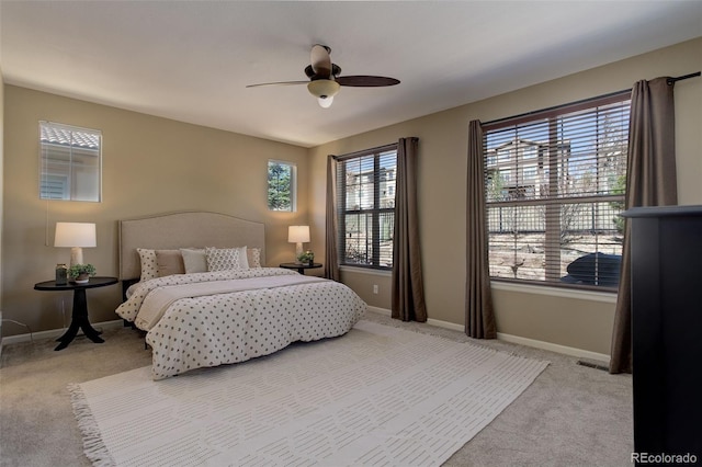 bedroom featuring visible vents, baseboards, ceiling fan, and light carpet