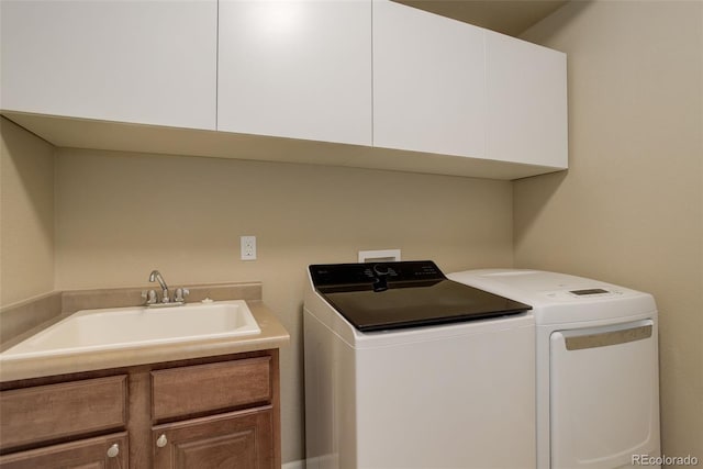 laundry area featuring washing machine and dryer, a sink, and cabinet space
