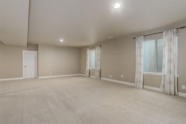 unfurnished room with baseboards, recessed lighting, and light carpet