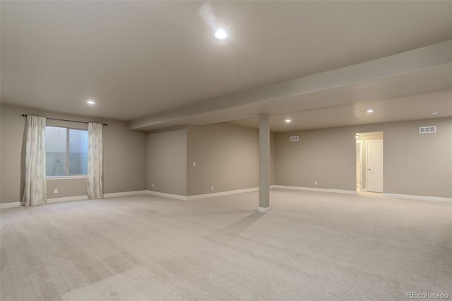 basement featuring light colored carpet, visible vents, and recessed lighting