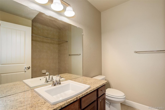 bathroom with vanity, baseboards, and toilet
