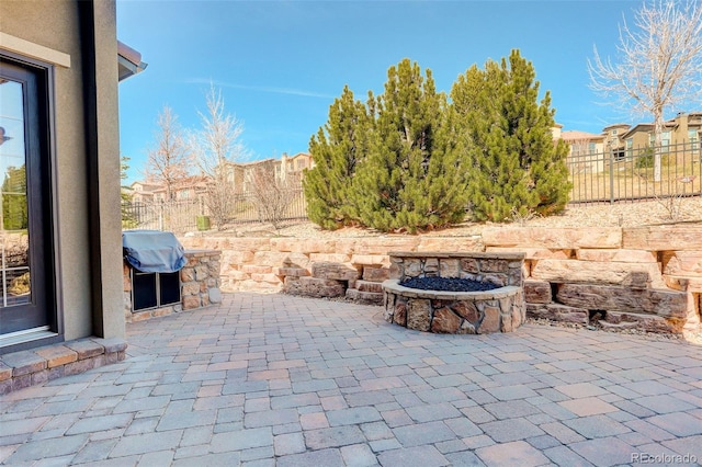 view of patio / terrace with a fenced backyard, a grill, a fire pit, and a residential view