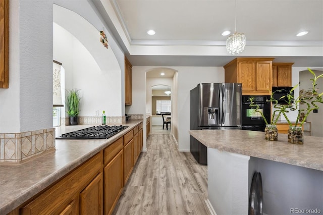 5293 Malaya St, Denver, CO 80249 - kitchen with light wood finished floors, arched walkways, brown cabinetry, stainless steel refrigerator with ice dispenser, and gas stovetop