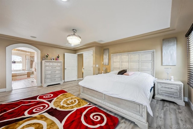 5293 Malaya St, Denver, CO 80249 - bedroom featuring arched walkways, light wood finished floors, and baseboards