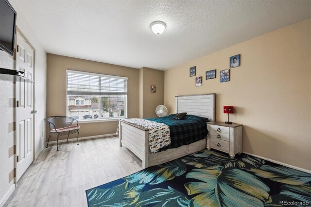 5293 Malaya St, Denver, CO 80249 - bedroom featuring light wood-type flooring, baseboards, and a textured ceiling