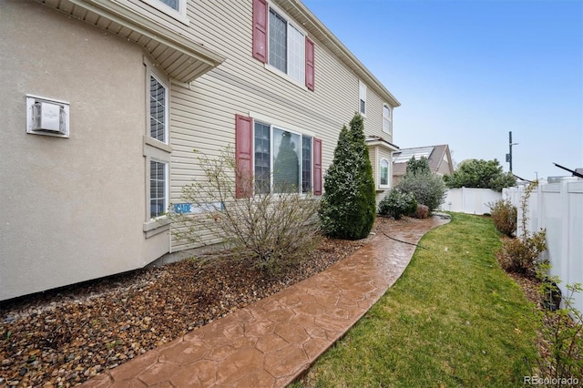 5293 Malaya St, Denver, CO 80249 - view of side of property featuring stucco siding, fence, and a yard