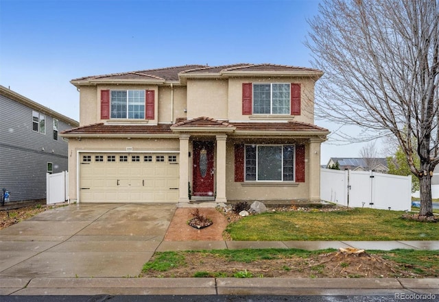 5293 Malaya St, Denver, CO 80249 - traditional-style house featuring a front lawn, concrete driveway, fence, an attached garage, and stucco siding