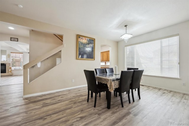 5293 Malaya St, Denver, CO 80249 - dining space featuring arched walkways, wood finished floors, and baseboards